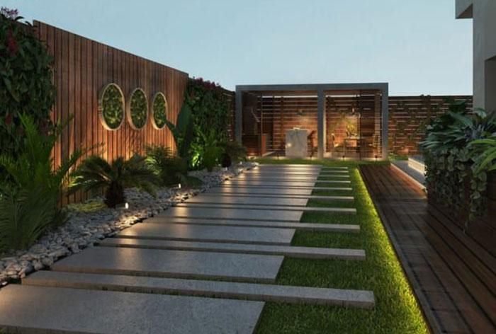 Modern villa garden with stone pathway, lawn strips and lighting