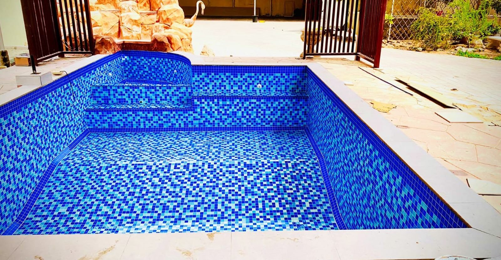 Mosaic-tiled swimming pool with steps